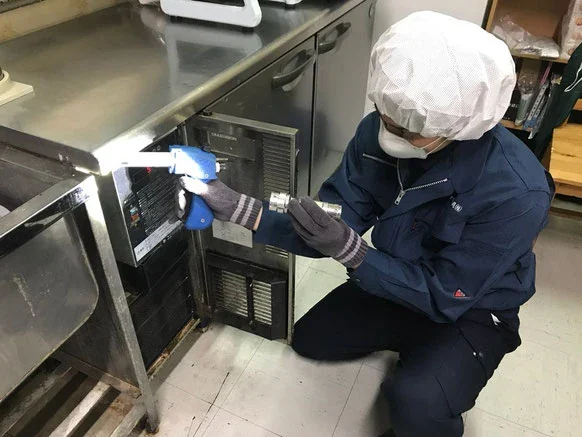 ペストマネージ沖縄株式会社 公式サイト掲載：厨房で機器を使う作業の写真